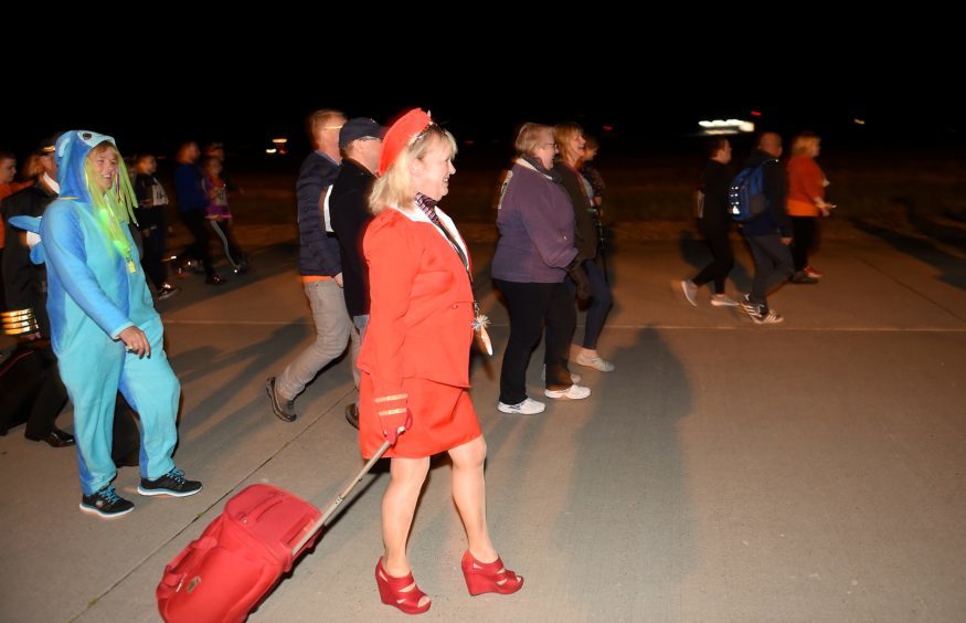Walkers and runners complete a three-mile course round the main runway of the airport.