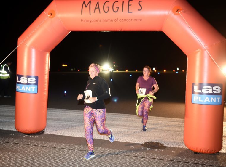 Runners and walkers cross the finishing line on the main runway. All pictures by Sandy McCook.