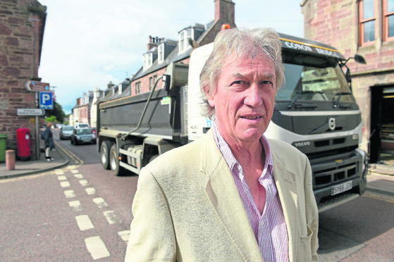 Concerns in Fortrose over damage to buildings and garden walls by the amount of heavy and conjested traffic having to use the villages High Street.  Community Council Chairman, Tom Heath in the centre of the village.
Picture by Sandy McCook.