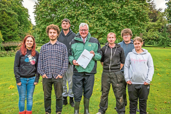 Cabinet Secretary Fergus Ewing (centre with document) with Newbattle Abbey College students.