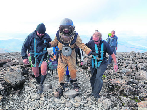 A team of divers have walked from the seabed to the summit of Ben Nevis while wearing a vintage diving suit - and in doubly quick time.