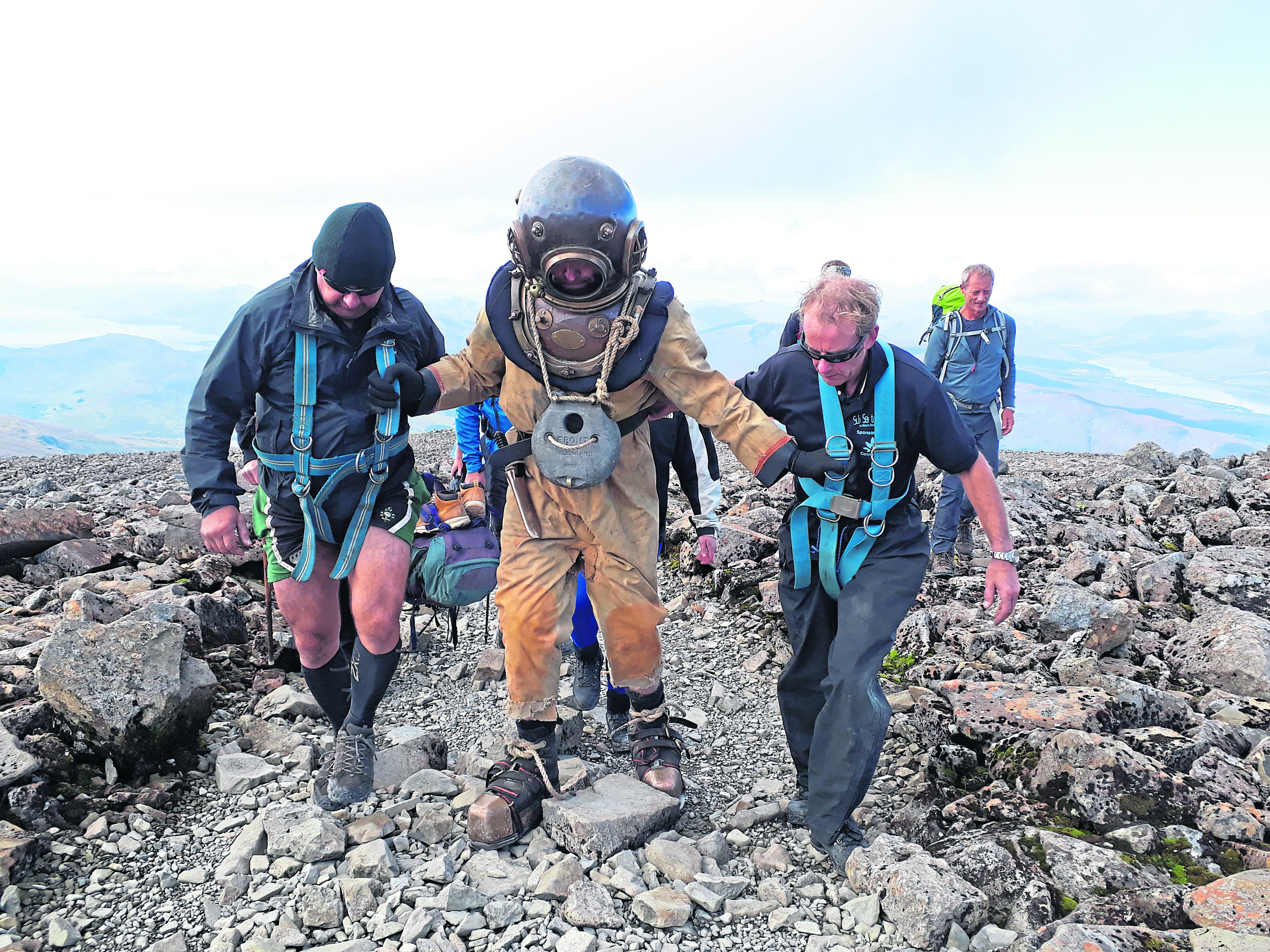 A team of divers have walked from the seabed to the summit of Ben Nevis while wearing a vintage diving suit - and in doubly quick time.