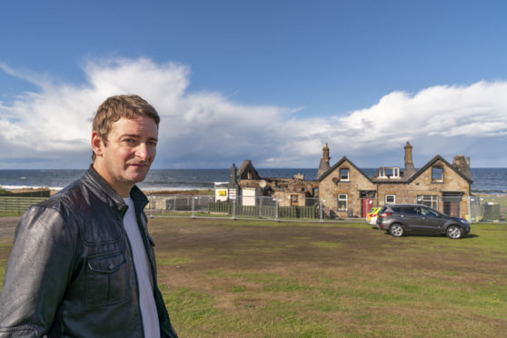 Owner of the Beach Bar, Graham Fleming, stands in front of the burnt out building.