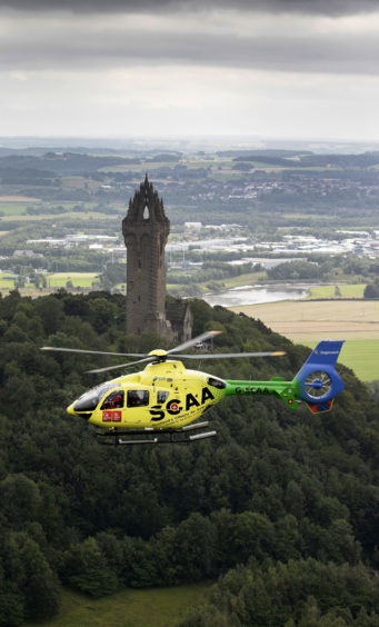 ‘Helimed 76’ is pictured flying over The National Wallace Monument in Stirling.