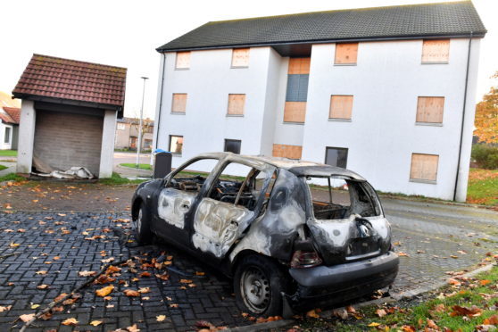 A burnt out renault car, at a block of boarded up flats at Marchburn, Northfield.    
Picture by Kami Thomson    26-101-7
