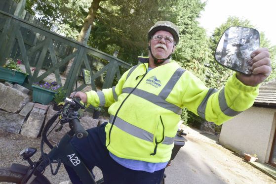 Colin Bruce with the mirror which knocked him off his bicycle.