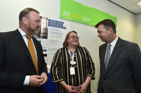DWP Minister Guy Opperman (R) talks to senior operations manager Suzanne Mann and MP David Dugui on his visit to Banff job centre.