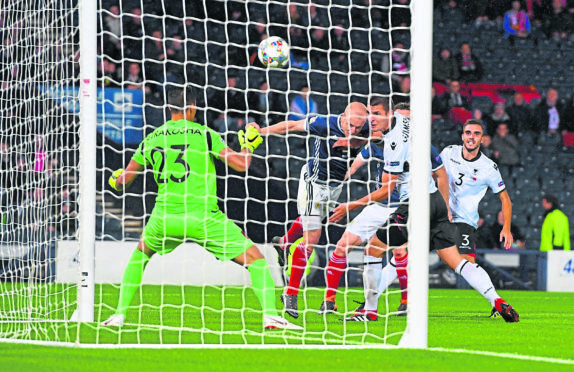 Scotland's Steven Naismith heads home a deflected opener