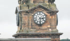 Workmen tidy up the steeple, despite the clock being stuck at 3.30