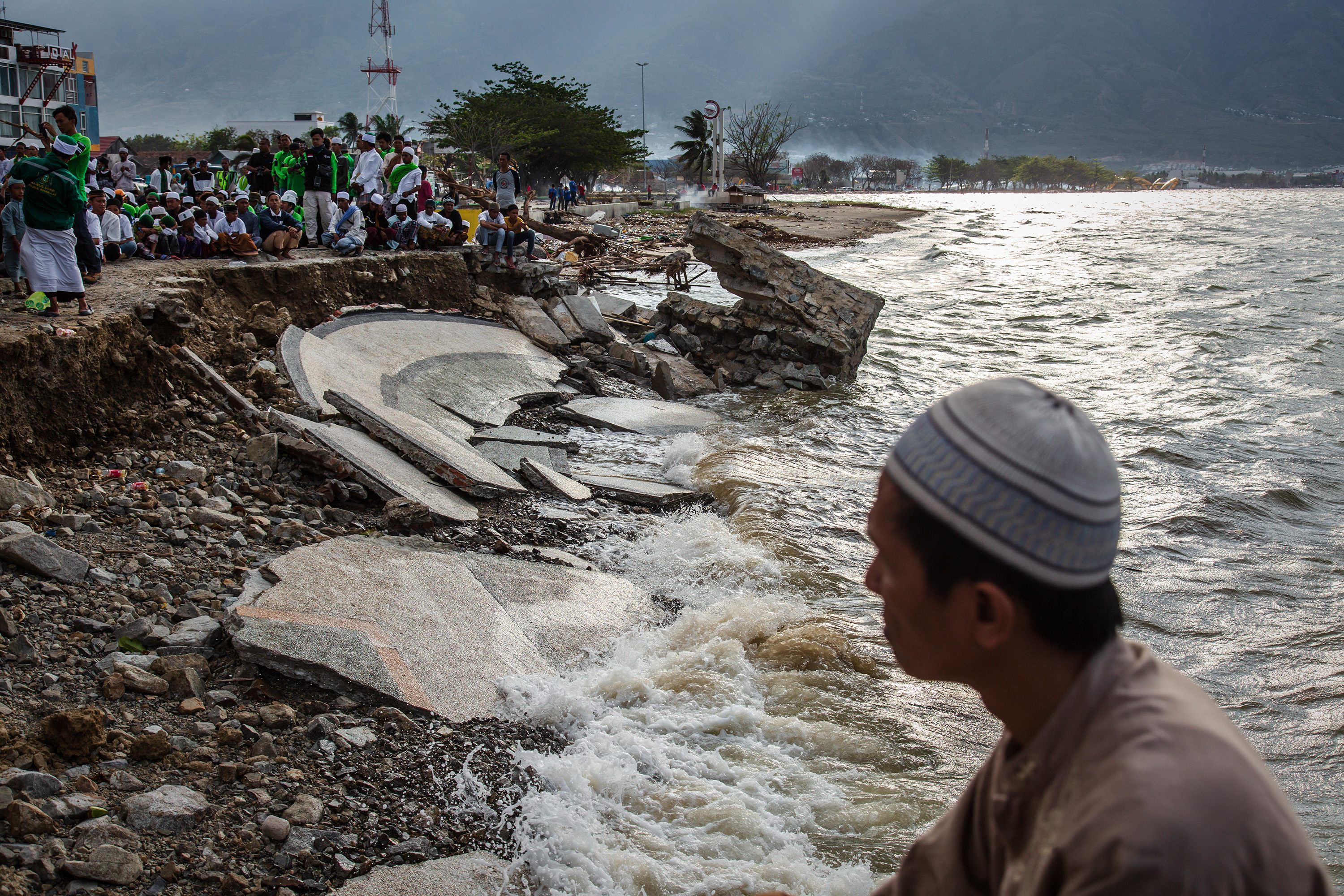 People attend mass prayer on Talise beach after being hit by a tsunami on October 12, 2018 in Palu, Indonesia. Photo by Ulet Ifansasti/Getty Images.