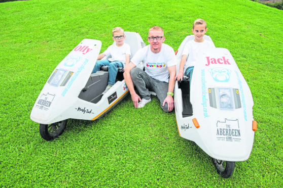 John Igesund with his two sons Jack and Olly, has two Sinclair C5s which are mini electric/pedal power vehicles from the 80s.