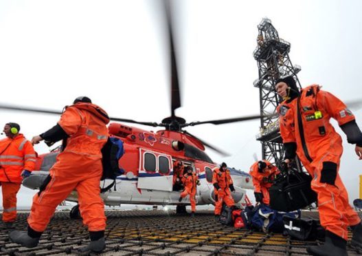 Offshore workers arrive on their platform by helicopter.