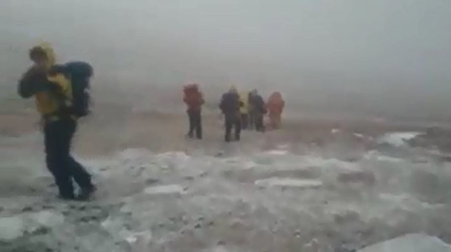 Mountain rescue teams battling snowy conditions.