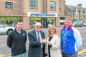 Royce Clark and his father James Clark, of Grampian Furnishers, hand over the keys to Jill and Jason Fletcher.