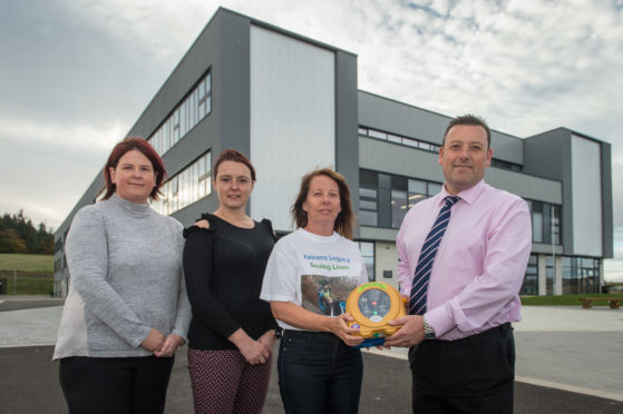 Gregor Girl members Janice Gregor and Yvonne Milton, Sandra McKandie and Elgin High School head teacher Hugh McCulloch with the donated defibrillator.