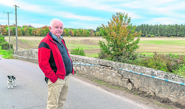 George Elder next to the damaged bridge over the Muckle Burn next to his Farm at Brodie,