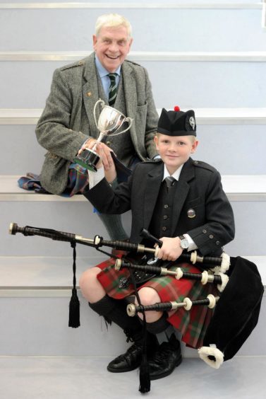 Logie Johnston of Oban High School, winner of the Roderick Ross, Ferintosh, Memorial Trophy for playing a march in the under thirteen age category. Also in the photograph is adjudicator Iain Macfadyen.