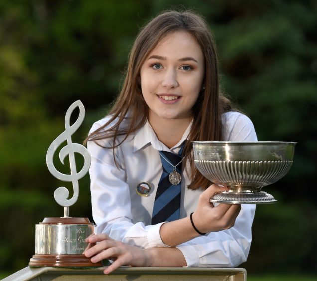 Holly MacLean of Tobermory with the Jean Graham Trophy and the Alexander Hamilton Trophy as aggregate trophies in the solo singing competitions in the 13-15 age group.