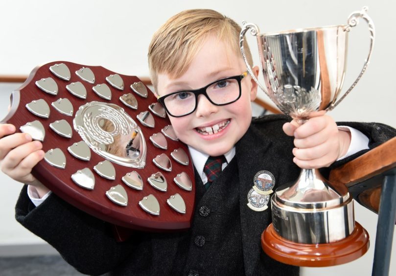 Jonathan Domhnallach of Kilmuir on Skye who celebrates his seventh birthday today (Wed) with the Alasdair Macinnes Memorial Cup for story telling and the Jeff McLaren Memorial Shield for singing a prescribed song in the six years and under age group.
