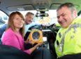 Sandra and Gordon McKandie presenting one of six life saving defibrillators to Road Policing Chief Inspector Stewart Mackie. Photo by Sandy McCook
