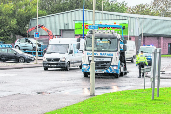 Police and recovery vehicles clear up after the crash.