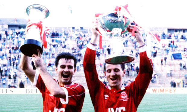 Aberdeen's Charlie Nicholas (left) holds the Skol Cup trophy and Paul Mason holds the League Cup trophy after their victory.