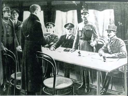 November 11 1918, in a railway coach at Compiegne, France, Supreme Allied Commander Marshal Foch stands to receive the  German plenipotentiaries.