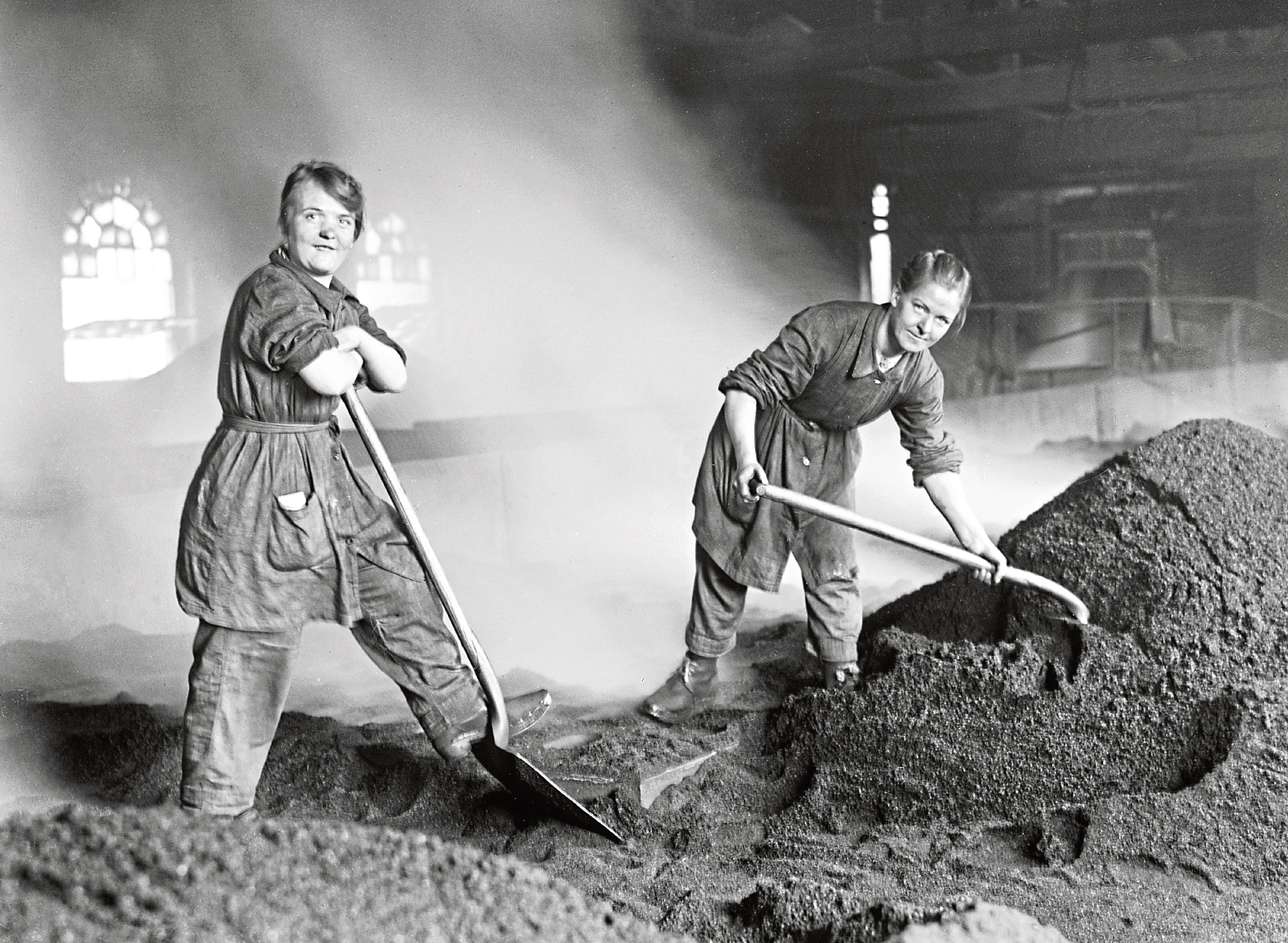 Women war workers feed the charcoal kilns used for purifying sugar at a Scottish refinery.