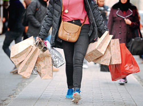 File photo dated 6/12/11 of a shopper carrying shopping bags. High street sales dropped by 2.2% last month in an "underwhelming" Christmas for many retailers, according to a report. ... High street sales ... 06-01-2014 ... London ... UK ... Photo credit should read: Dominic Lipinski/PA Wire. Unique Reference No. 18604411 ... Issue date: Monday January 6, 2014. Figures from accountancy firm BDO showed the sales surge hoped for by many shops failed to materialise in the crucial trading period, with like-for-like sales - excluding online trade - dropping by as much as 6.7% in the week to December 22. See PA story ECONOMY Retail. Photo credit should read: Dominic Lipinski/PA Wire