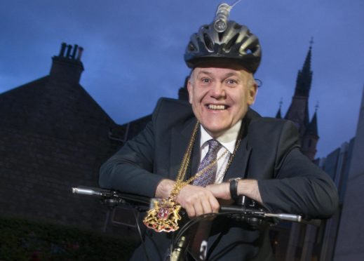 former Lord Provost Barney Crockett with the chains of the role on a bike. Image: DC Thomson.