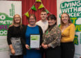 Fiona Lewis, centre left, received the prestigious David MacMillan Award for services to MacMillan Cancer from Isla Dewar, the charity's North of Scotland fundraising manager.