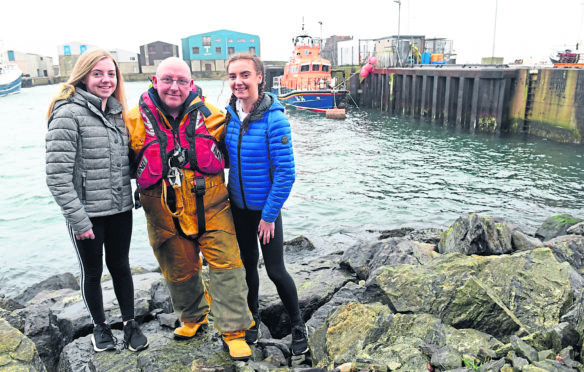 Coxswain of the Fraserburgh lifeboat Vic Sutherland with his daughters Ailsa (left) and Eilidh who are both taking part in the boxing day swim at the harbour in aid of the RNLI.