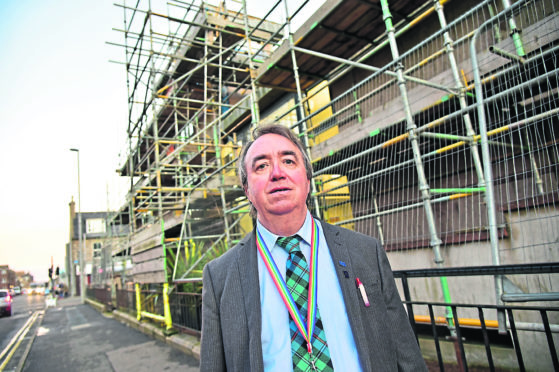 Councillor Stephen Calder at the sheriff court building in Peterhead where scaffolding is becoming an eyesore.