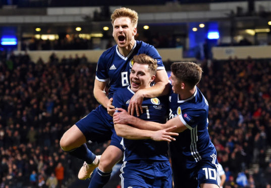 Scotland's James Forrest celebrates after scoring to make it 2-1, with Stuart Armstrong (left) and Ryan Christie