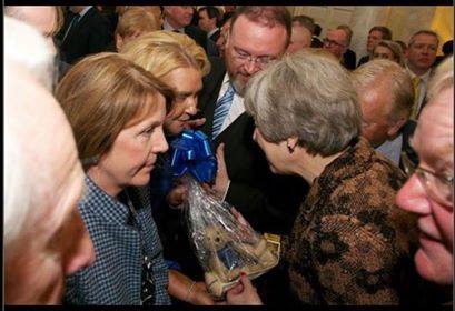 Councillor Dianne Beagrie with MP David Duguid handing over the handmade Peterhead bear to Theresa May