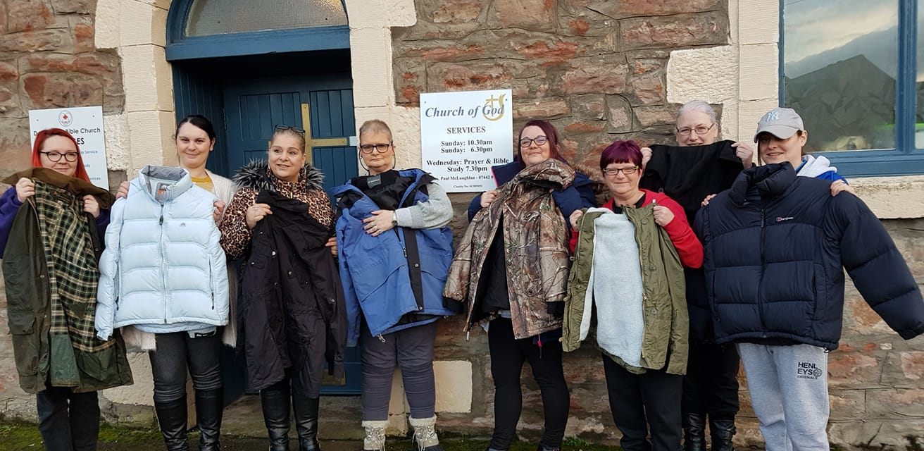 Members of Serenity pictured with the donated jackets, some of which have been distributed to the city's homeless.