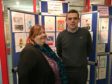 Douglas Ross MP with Jane Sandell, Moray Libraries Senior Librarian Young People’s Services, in front of the display of entries for the Moray Christmas Card Design Competition in Elgin Library