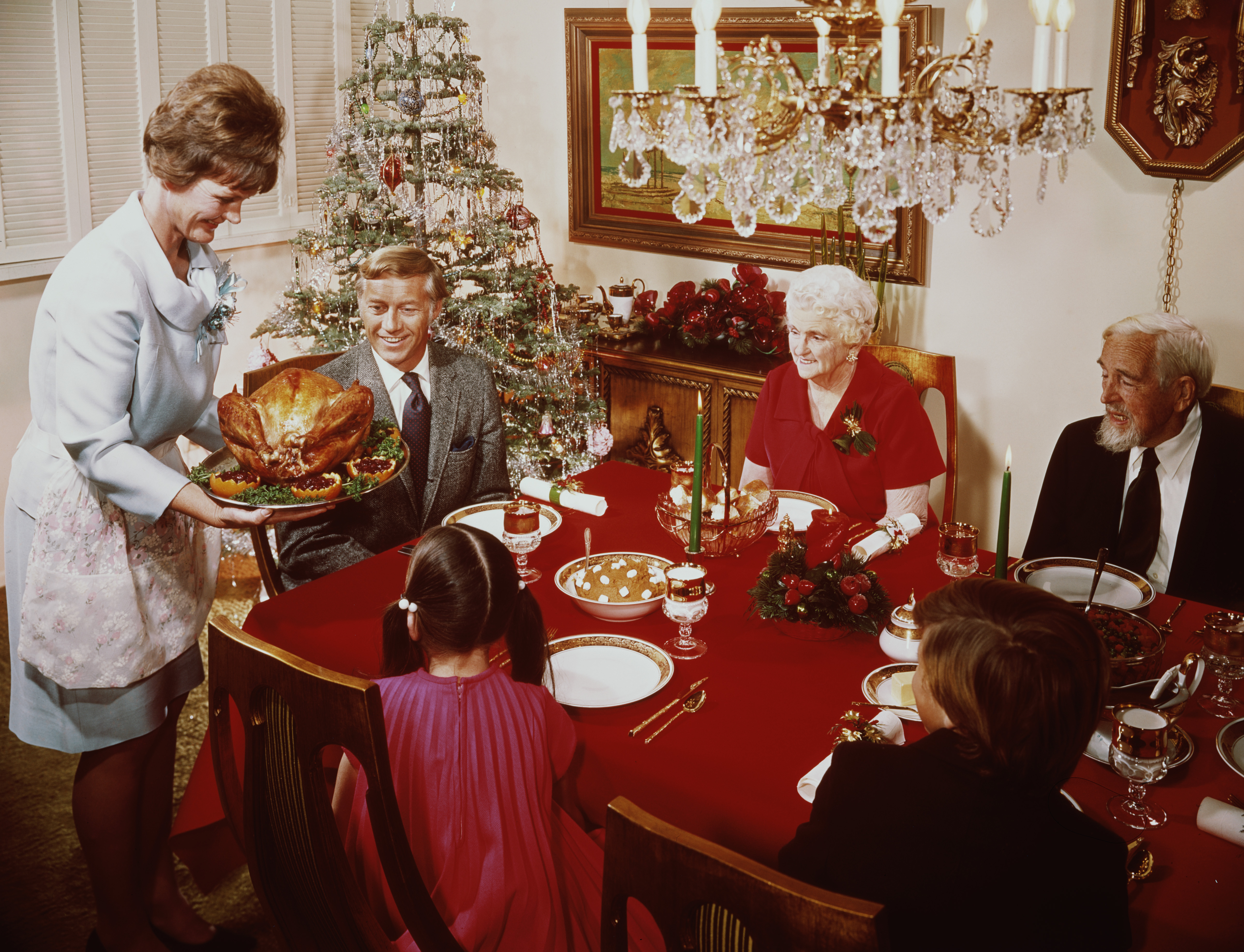 A mother bringing a large turkey to the table for Christmas dinner, circa 1965. (Photo by L. Willinger/FPG/Hulton Archive/Getty Images)