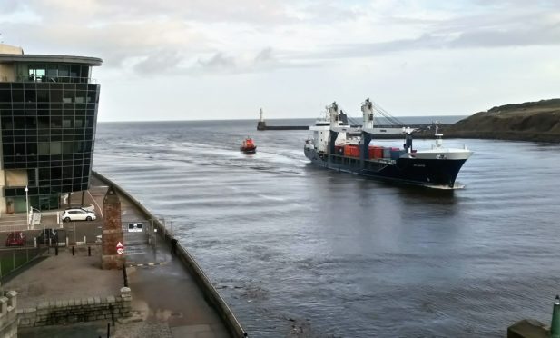 : MV Atlantic, with RNLI casualty care crew on board attending the injured harbour pilot, being escorted to her berth by Aberdeen Lifeboat