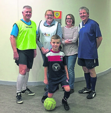 Ruaridh Campbell pictured with (R) Alison Holmes (the senior Staff Nurse whose appointment to this area was triggered by last January’s Sneckie Insomnia Soccer event) and (L) Fiona Scott Senior  Chas Nursing Support Worker. Looking on are (R) Graham Cross Chairman of Inverness Business Fives Group and (L) Ron Cruickshank the instigator of the Sneckie Insomnia Soccer initiative.