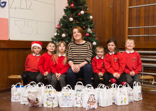 Pupils from Mosstodloch Primary with their food bags and Gillian Pirie from Moray Foodbank