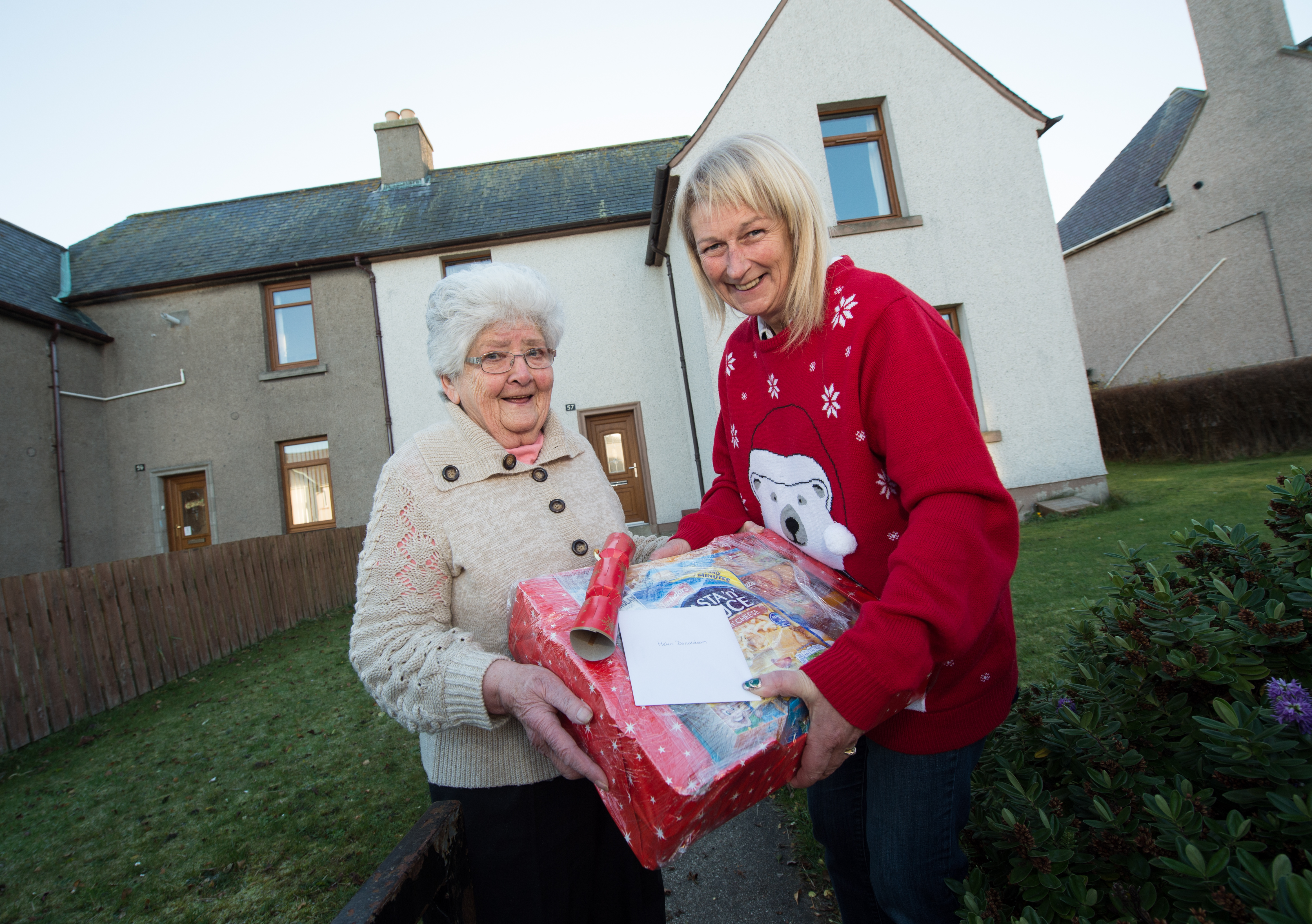 Pictures show Land lady, Lynn Mitchell of The Brander Arms in Lossiemouth with her food parcels and delivering the parcels to an older lady in Lossiemouth. In the bar you can see all of the donation envelopes.

Picture: Lyn Mitchell (right) and (left) Helen Donaldson.