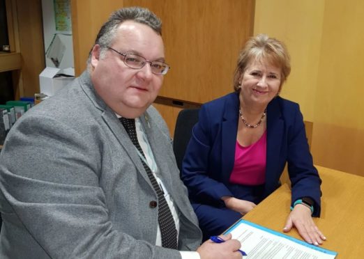 Moray Council leader Graham Leadbitter signs the charter with the Scottish Government's environment and climate change minister Roseanna Cunningham.
