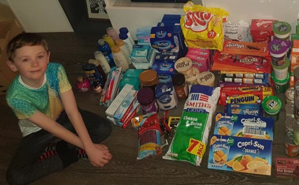 Riley Winton, age 10, with some of the food and essentials he donated to the homeless