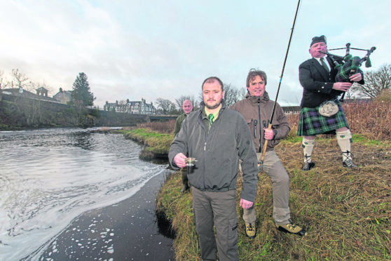 Piper Alistair Miller plays a tune as senior ghillie Geordie Doull prepares to toats the Thurso River, while East Yorkshire businessman Angus Oughtred stands by to cast the first fly. Looking on is River superintendant Tim Hawes. Photo: Robert MacDonald/Northern Studios.