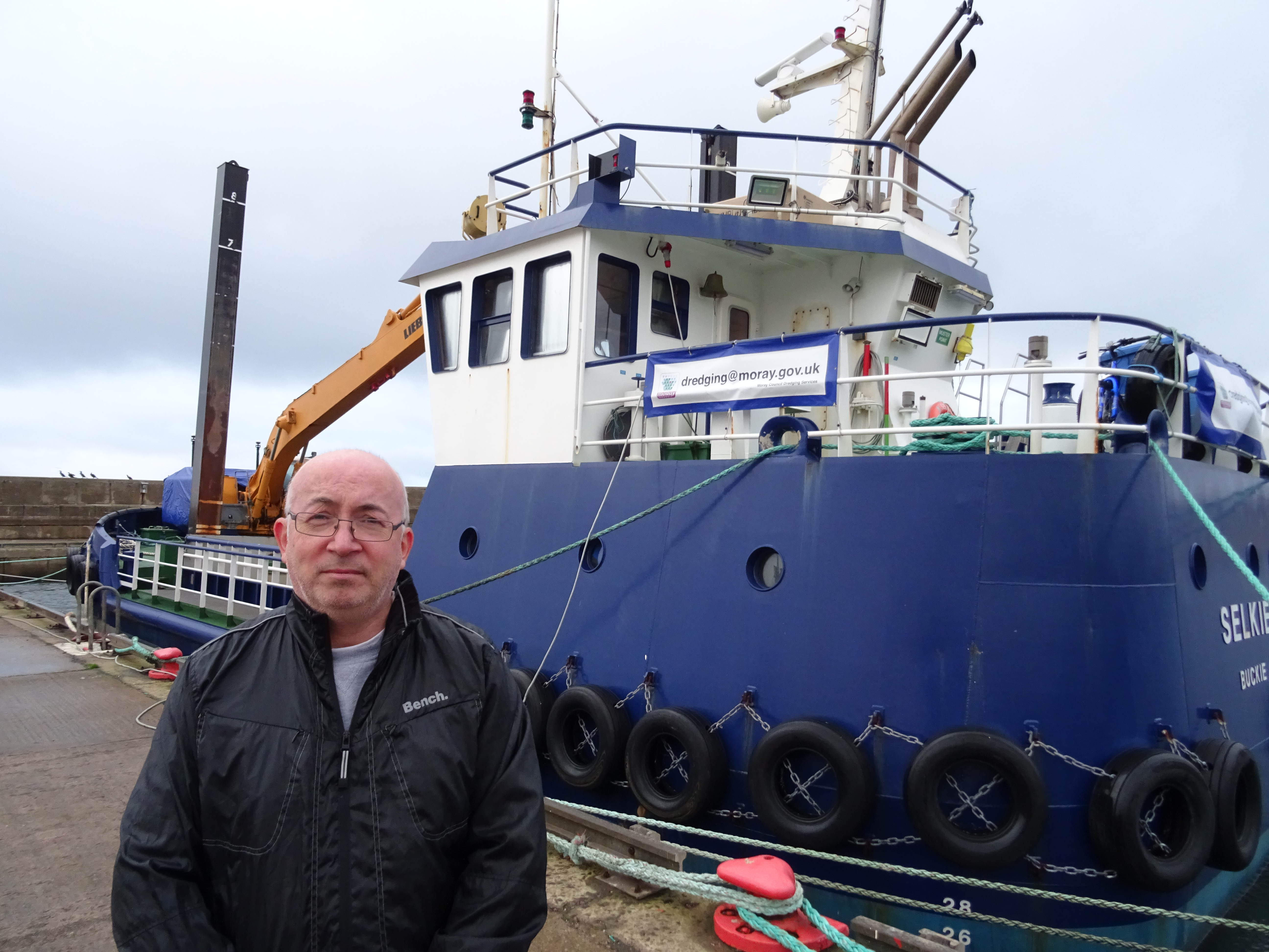 Marc Macrae beside the Moray Council dredger