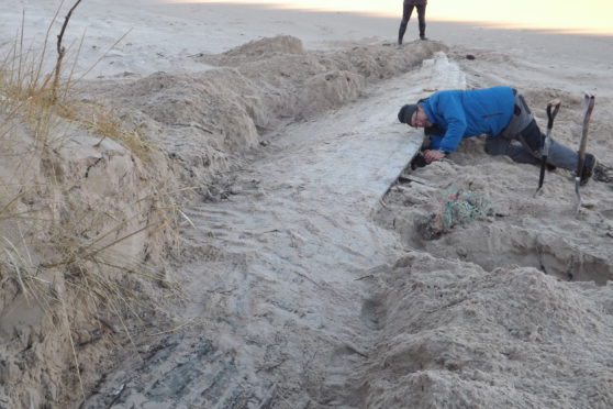 Members of Nairn Sailing Club turned out to help dig the mysterious vessel out from beneath the sand dune.