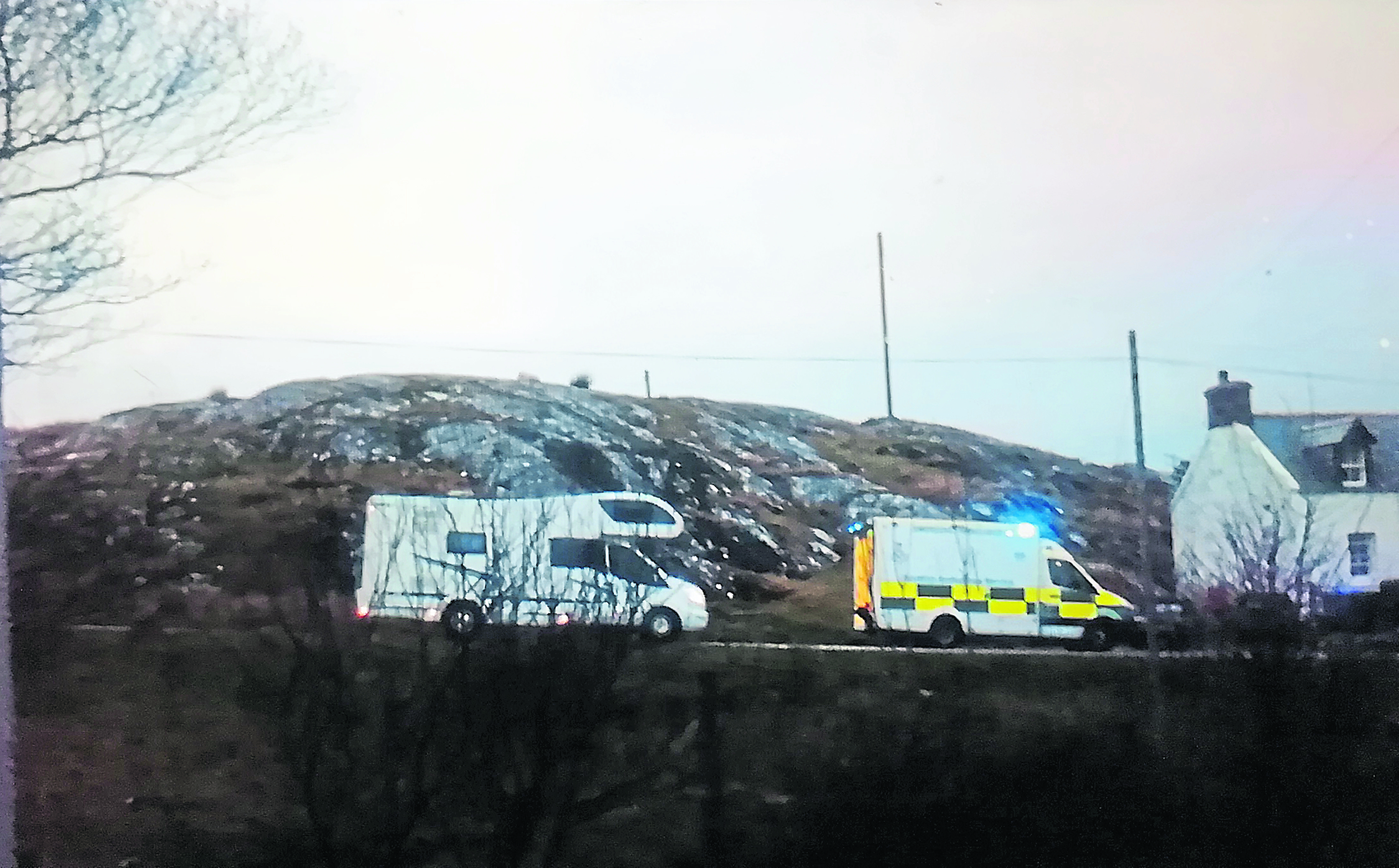 A camper van waits to pass the ambulance on the NC500 route.