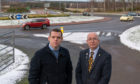 MP Douglas Ross and Councillor Marc Macrae at the roundabout junction of the A98 A96 and Fochabers Village entrance.