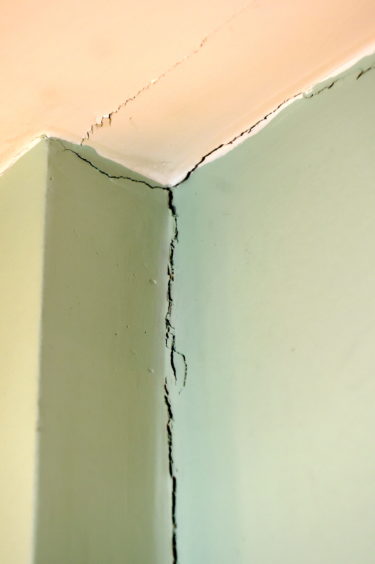 Cracks on the wall show the damage that is still to be repaired.